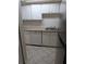 View of a kitchen with white cabinets, a stainless steel sink, a dishwasher, light countertop, and tiled floors at 524 Northridge Crossing Dr, Atlanta, GA 30350