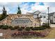 Stone entrance sign for Morningside Village with flowers, landscaping and a view of modern townhomes in the background at 1277 Sunny Lake Dr, Lawrenceville, GA 30043