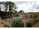 Community playground featuring a slide, climbing wall, swings, and a secure fenced area for enjoyment at 1277 Sunny Lake Dr, Lawrenceville, GA 30043