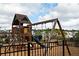 Community playground featuring a slide, climbing wall, swings, and a secure fenced area for enjoyment at 1277 Sunny Lake Dr, Lawrenceville, GA 30043