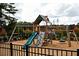 Community playground featuring a slide, climbing wall, swings, and a secure fenced area for enjoyment at 1277 Sunny Lake Dr, Lawrenceville, GA 30043