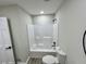 Clean white bathtub and toilet in the bathroom, accented with modern black fixtures and gray vinyl plank flooring at 295 Lamden Ct, Lawrenceville, GA 30046