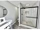 Modern bathroom with glass-enclosed shower, pebble floor, and sleek fixtures at 295 Lamden Ct, Lawrenceville, GA 30046