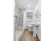 Bathroom featuring a marble-tiled shower, modern fixtures, and a pedestal sink, creating a clean, updated look at 750 Parkway Se Dr, Smyrna, GA 30080
