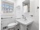 Bathroom showcasing a white pedestal sink, a window for natural light, and modern chrome fixtures at 750 Parkway Se Dr, Smyrna, GA 30080