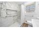 Accessible bathroom featuring marble-tiled shower with built-in seat and grab bars, alongside modern fixtures at 750 Parkway Se Dr, Smyrna, GA 30080