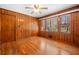 Cozy bedroom featuring wood paneling, hardwood floors and a ceiling fan at 750 Parkway Se Dr, Smyrna, GA 30080