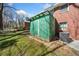 Side view of a brick home with a green storage shed and HVAC unit on the lawn at 750 Parkway Se Dr, Smyrna, GA 30080