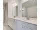 Bright bathroom features a double vanity with white cabinets and sleek hardware, and two framed mirrors at 209 Haverling Pass, Hampton, GA 30228