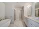 Bathroom showcasing soaking tub, separate shower, and double vanity with stylish modern fixtures at 209 Haverling Pass, Hampton, GA 30228