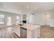 Kitchen island with stainless steel dishwasher and sink overlooks the home's large living room at 209 Haverling Pass, Hampton, GA 30228