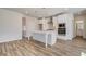 Bright kitchen features white cabinets, stainless steel appliances, and an island with pendant lighting at 209 Haverling Pass, Hampton, GA 30228