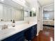 Bathroom with large mirror over vanity and doorway leading to bedroom with hardwood flooring at 64 Montre Nw Sq, Atlanta, GA 30327