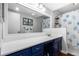 Bright bathroom with blue vanity, large mirror, and a shower with a decorative blue and white curtain at 64 Montre Nw Sq, Atlanta, GA 30327
