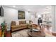 Open-concept living room with hardwood floors, modern artwork, and a glimpse of the kitchen and dining area at 64 Montre Nw Sq, Atlanta, GA 30327