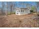 Rear view of the house with a large yard with trees. The home has a sunroom with many windows at 79 Mountain View Ct, Dallas, GA 30157