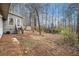 Back view of the house showing a staircase, a shed, and a large backyard with grass and woods at 79 Mountain View Ct, Dallas, GA 30157