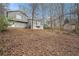 Wide shot of the back of the house with a large yard, sunroom, shed, and surrounding woods at 79 Mountain View Ct, Dallas, GA 30157