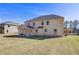 Grassy backyard showcasing the home's brick exterior and covered patio at 200 Haverling Pass, Hampton, GA 30228