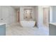 Bright bathroom featuring freestanding tub, marble tile, and stylish fixtures at 200 Haverling Pass, Hampton, GA 30228