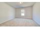 A spacious bedroom with plush carpet, a window, and neutral wall paint at 200 Haverling Pass, Hampton, GA 30228