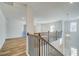 Bright hallway with wood floors, wrought iron railing, and pendant lighting at 200 Haverling Pass, Hampton, GA 30228