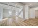 Bright and airy living room featuring hardwood floors, coffered ceilings, and modern chandelier lighting at 200 Haverling Pass, Hampton, GA 30228