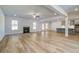 Open-concept living room with fireplace, hardwood floors, and seamless flow to kitchen area at 200 Haverling Pass, Hampton, GA 30228