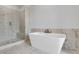 Spa-like bathroom with marble tile shower, stylish soaking tub, and elegant fixtures for relaxation at 587 Red Clay Farm Ln, Suwanee, GA 30024