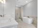 Serene bathroom featuring a freestanding tub, glass shower, and double vanity with stone tile at 587 Red Clay Farm Ln, Suwanee, GA 30024