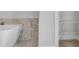 Bathroom features marble tile, standalone tub, and adjacent walk-in closet at 587 Red Clay Farm Ln, Suwanee, GA 30024