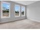 Bedroom with three windows and plush neutral carpet at 587 Red Clay Farm Ln, Suwanee, GA 30024