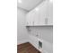 Well-organized laundry room with ample white cabinetry and modern wood floors at 587 Red Clay Farm Ln, Suwanee, GA 30024