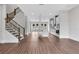 Open concept living room with a staircase, modern kitchen, and hardwood floors at 587 Red Clay Farm Ln, Suwanee, GA 30024