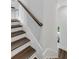 Staircase with dark wood treads, white walls and a simple wood handrail at 587 Red Clay Farm Ln, Suwanee, GA 30024