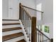 Elegant staircase with wood treads, white risers, and black metal balusters for a modern, sophisticated look at 587 Red Clay Farm Ln, Suwanee, GA 30024
