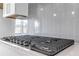 The stovetop has a sleek design with a gray subway tile backsplash and modern appliances at 587 Red Clay Farm Ln, Suwanee, GA 30024