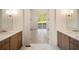 Dual vanities, hardwood floors, modern fixtures, and backyard views in this light, bright bathroom at 906 Fairfield Dr, Marietta, GA 30068