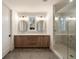 Well-lit bathroom featuring double sinks with hardwood cabinets, a quartz countertop, and glass shower at 906 Fairfield Dr, Marietta, GA 30068