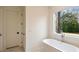 Bright bathroom featuring a freestanding tub and a large window with a view of the backyard at 906 Fairfield Dr, Marietta, GA 30068