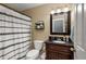 Cozy bathroom featuring a vanity with dark countertop, framed mirror, and decorative black-and-white shower curtain at 1027 Deer Hollow Dr, Woodstock, GA 30189