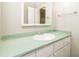 Clean bathroom featuring white cabinets, green counters, a mirror and lots of natural light at 4055 S Bogan Rd, Buford, GA 30519