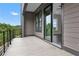 This image shows a large outdoor balcony with sliding glass doors, offering an indoor/outdoor living experience at 557 Red Clay Farm Ln, Suwanee, GA 30024
