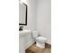 This bathroom features a pedestal sink and toilet, with wood look flooring and fresh paint at 557 Red Clay Farm Ln, Suwanee, GA 30024