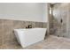 A luxurious bathroom with a modern tub and a glass-enclosed shower at 557 Red Clay Farm Ln, Suwanee, GA 30024