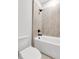 Close up of bathroom featuring neutral tile, modern fixtures, and a white tub at 557 Red Clay Farm Ln, Suwanee, GA 30024