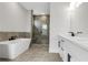 Modern bathroom featuring a soaking tub, glass shower, and double sink vanity at 557 Red Clay Farm Ln, Suwanee, GA 30024