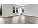 This bedroom features hardwood floors and large windows for plenty of natural light at 557 Red Clay Farm Ln, Suwanee, GA 30024