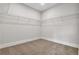 Walk-in closet provides ample storage space with wire shelving and neutral carpeting at 557 Red Clay Farm Ln, Suwanee, GA 30024