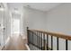 Hallway featuring hardwood floors, white walls, and a wooden staircase at 557 Red Clay Farm Ln, Suwanee, GA 30024